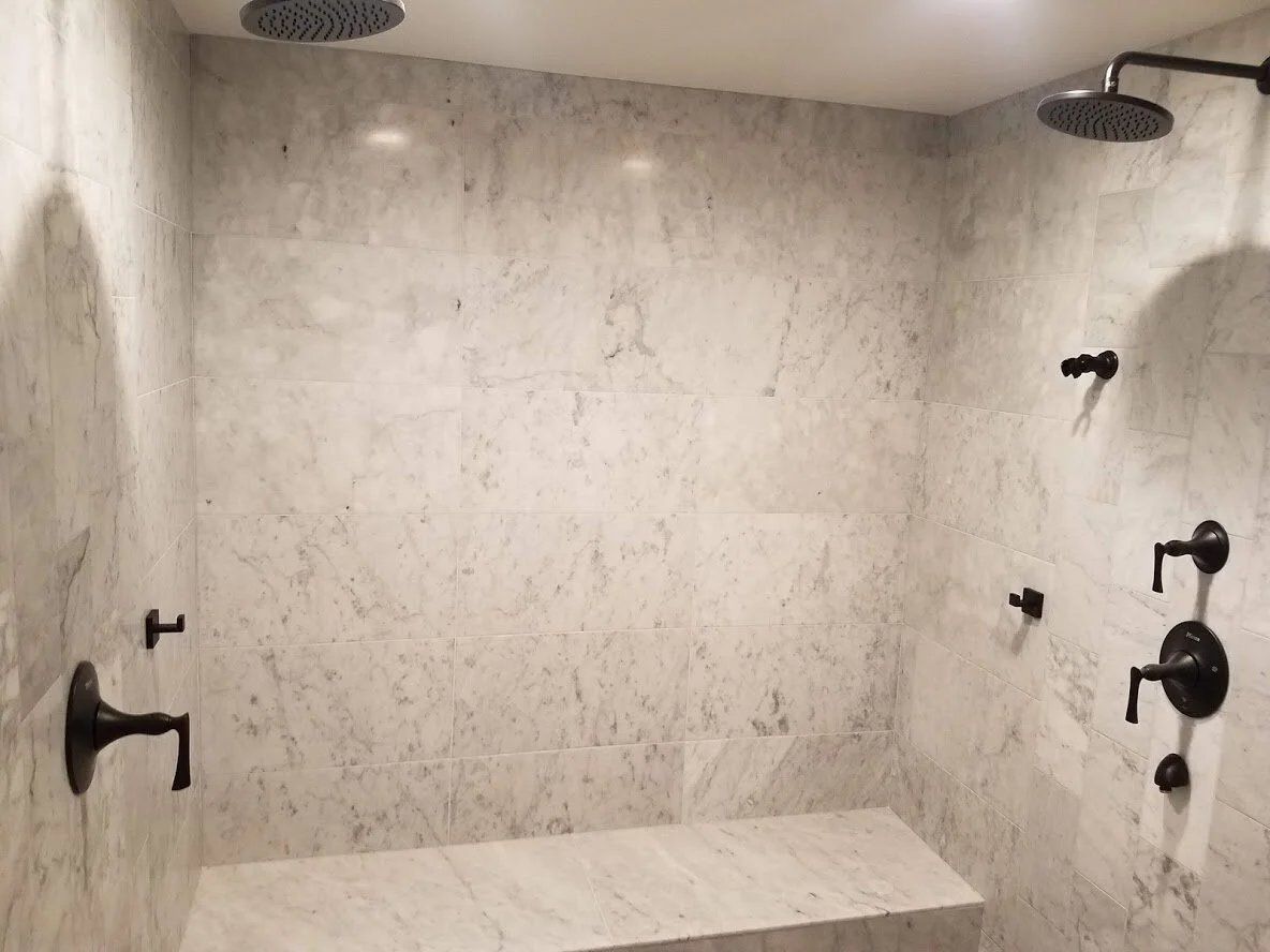 Marble shower with twin rain heads and bench