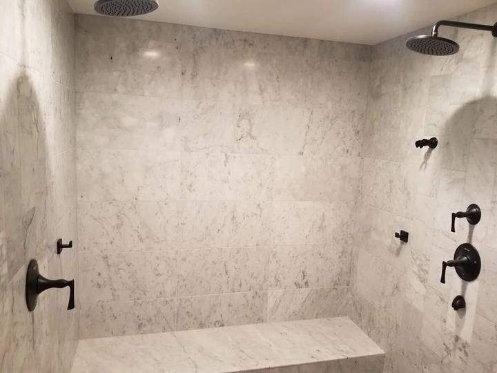 Marble shower with twin rain heads and bench